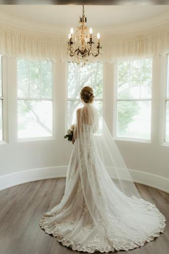 A bride looks out the window at the Norland, an estate wedding and event venue